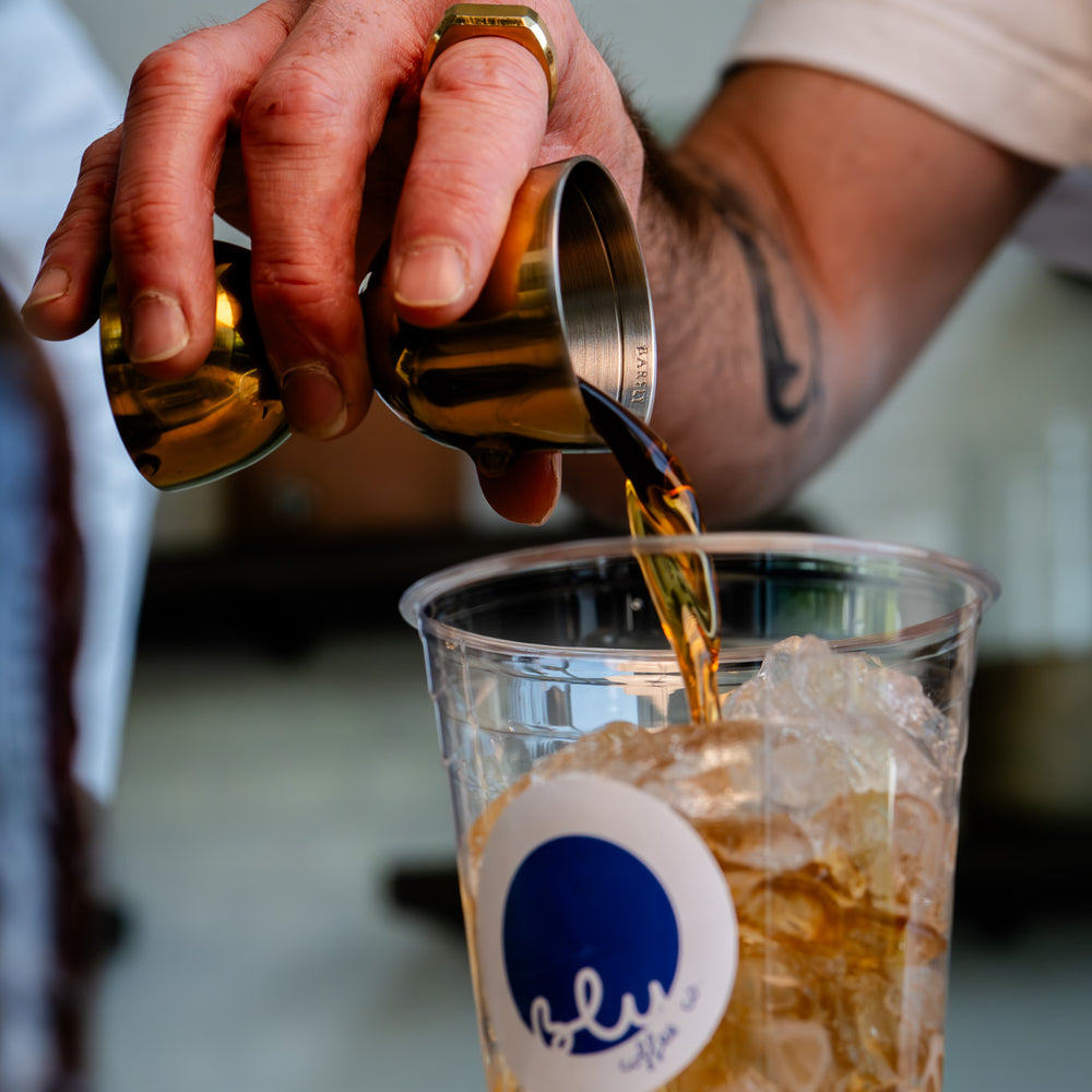 image of syrup being poured into iced latte